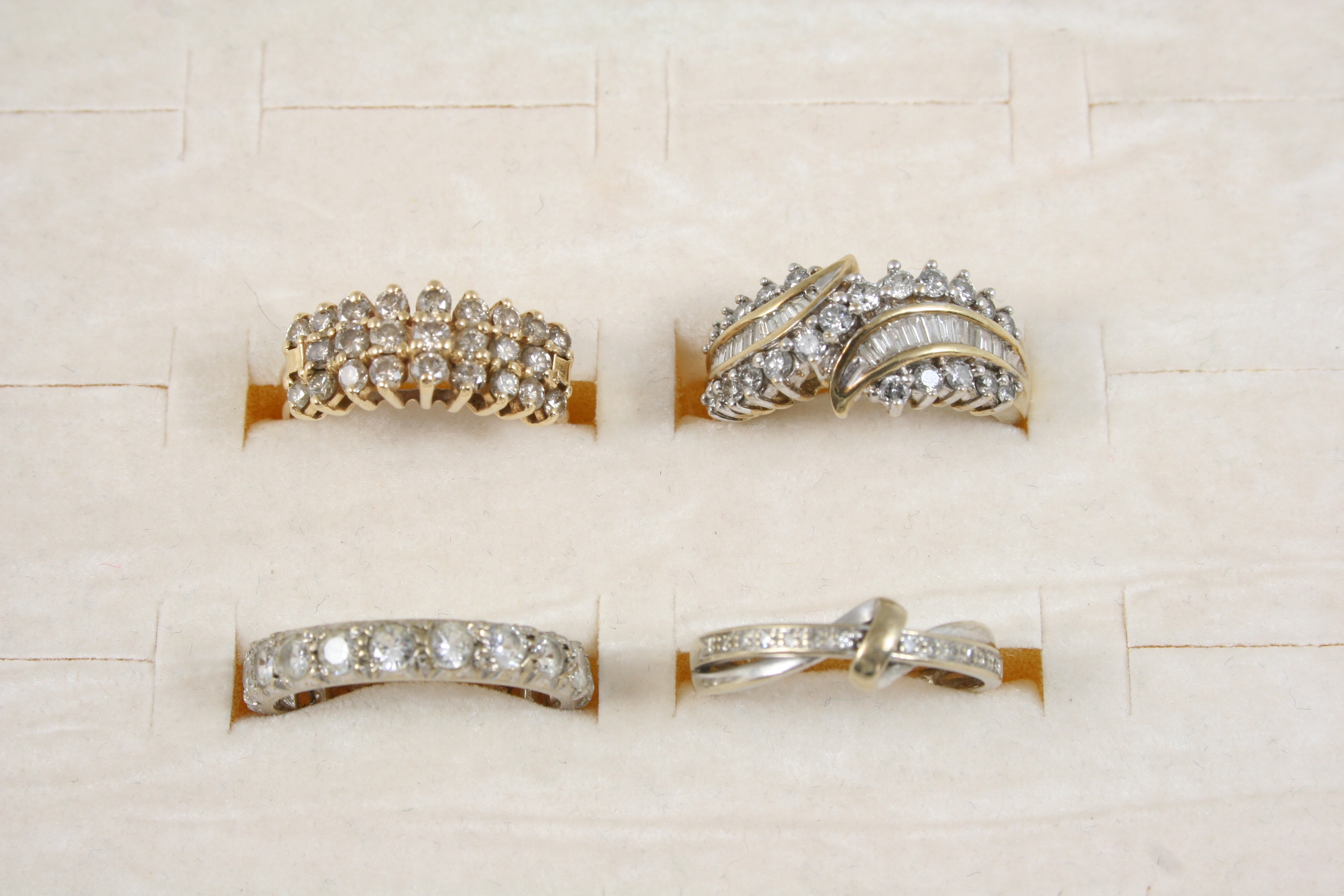 THREE ASSORTED GOLD AND DIAMOND SET RINGS together with a paste set eternity ring.