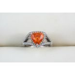 A MANDARIN GARNET AND DIAMOND RING the triangular-shaped garnet weighs 2.56 carats and is set within