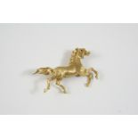 AN 18CT. GOLD HORSE BROOCH realistically formed, with ruby eye, 5cm. wide, 10.8 grams.