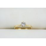 A DIAMOND SOLITAIRE RING the circular-cut diamond is set in 18ct. gold. Size M.