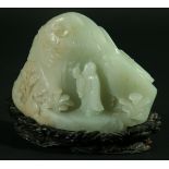 A CHINESE CELADON JADE BOULDER CARVING, with hints of russet, a traveller standing before a tree and