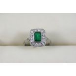 AN EMERALD AND DIAMOND CLUSTER RING the emerald-cut emerald is set within a surround of four