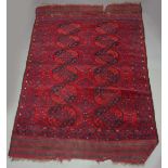 AN AFGHAN CARPET, two runs of six guls inside a multistrap border, in tones of red and blue, with