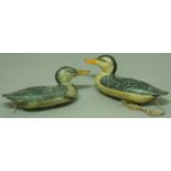 A PAIR OF CARVED WOODEN DECOY DUCKS probably 19th Century, with painted plumage and lead weights,