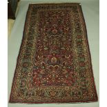 A PERSIAN CARPET, a central panel of stylised flowers and foliage inside a broad five strap