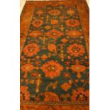 A TURKISH CARPET Stylised flowerheads and foliage on a blue ground, inside a broad border with