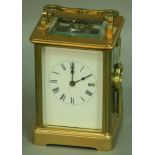 A FRENCH BRASS FOUR PANE CARRIAGE CLOCK, with white enamelled dial, eight day movement half hourly