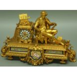 A FRENCH GILT METAL MANTLE CLOCK, late 19th century, a seated figure of an artist beside an urn