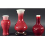 THREE CHINESE SANG DE BOEUF VASES, 19th century, of baluster, inverted baluster and bottle form, the