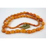 A SINGLE ROW GRADUATED AMBER BEAD NECKLACE 90cm. long, 103 grams.