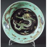 CHINESE FAMILLE NOIR SAUCER DISH probably late 18th century, a scrolling dragon chasing a flaming
