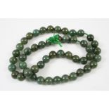A SINGLE ROW UNIFORM JADE BEAD NECKLACE the jade beads measure approximately 13.3mm., 66cm. long.