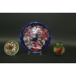 MOORCROFT POTTERY including a large plate in the Anemone design, a small lidded ginger jar in the