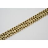 AN 18CT. GOLD FANCY LINK BRACELET the textured links are set to a concealed clasp, 18cm. long, 61