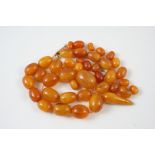 A QUANTITY OF LOOSE AMBER BEADS 59 grams.