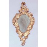 GEORGE II GILT GESSO LOOKING GLASS, of rococo form with trellis piercing, the plate with a central
