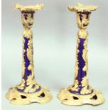 PAIR OF PORCELAIN AND GILT METAL MOUNTED CANDLESTICKS, the blue sconce and column encased in pierced