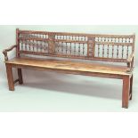 OAK HALL BENCH, 19th century, the spindle back with foliate panels on a solid seat, 97cm, width
