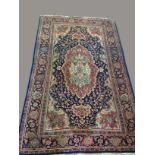 SAROUKH RUG, the deep indigo field of floral vines around a pale madder and ivory pole medallion