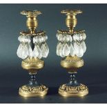 PAIR OF FRENCH EMPIRE STYLE BRONZED CANDLESTICKS, the foliate drip tray with cut glass lustres on
