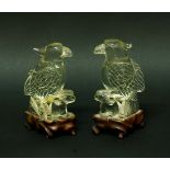 PAIR OF CHINESE ROCK CRYSTAL CARVINGS OF PARROTS, 19th century, each with a claw resting on a