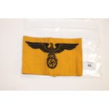 A GERMAN ARMBAND. A Nazi Armband in mustard cloth with black Eagle over Swaztika design, official