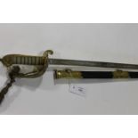 A NAVAL OFFICERS SWORD. A 20thC Naval Officers sword and scabbard with brass and leather mounts. The