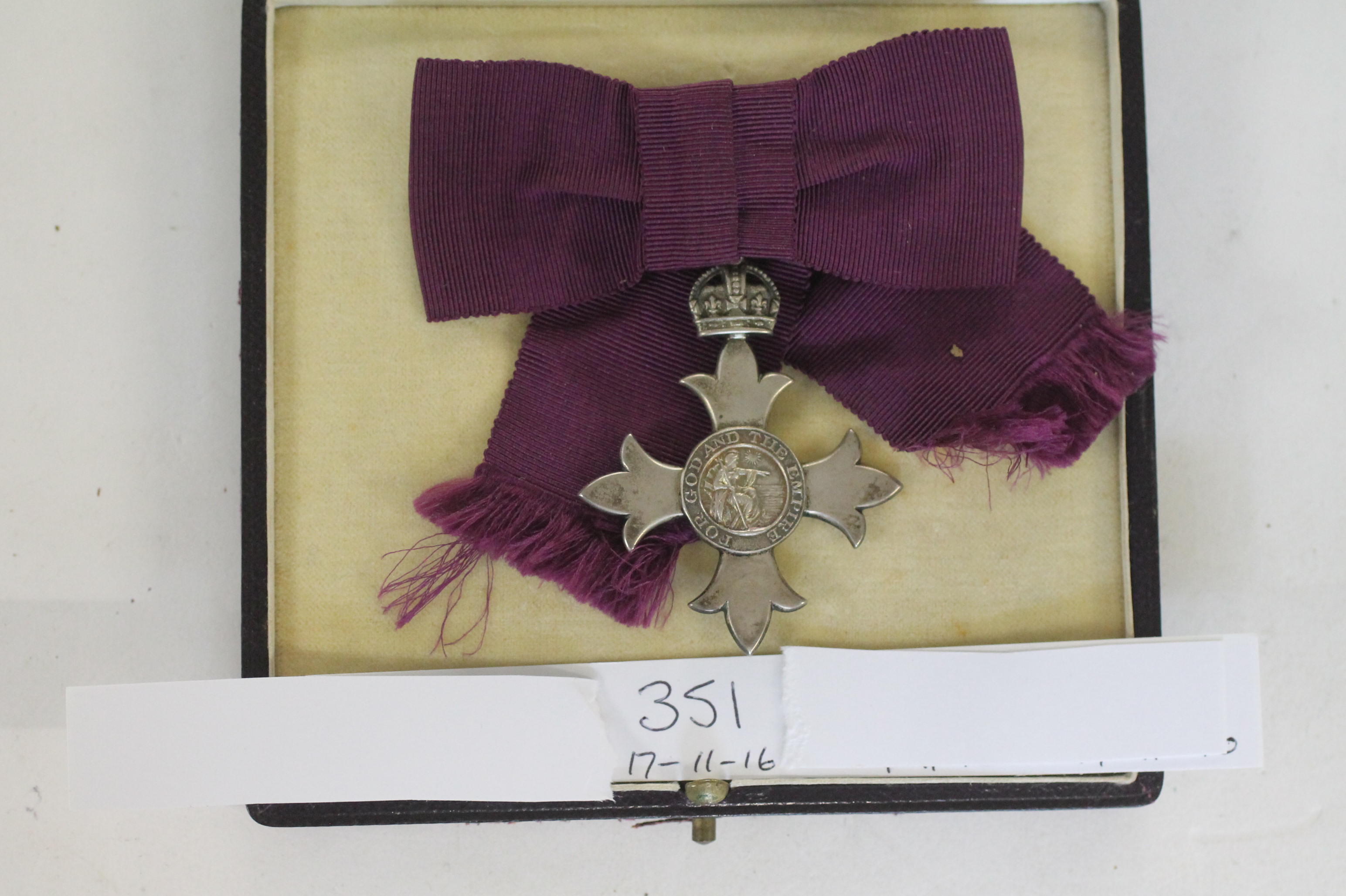 A CASED LADIES MBE. A ladies bow-mount MBE 1st type with purple ribbon.
