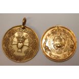 TWO ORNATE GOLD MEDALLIONS. Weighing 28 grams with one missing it top ring mount, both around 30mm