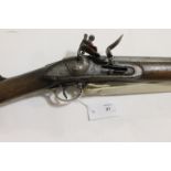 A BROWN BESS. A Brown Bess musket with 39" barrel, steel ramrod below and lock with the date 1813