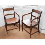 A pair of Regency mahogany elbow chairs, with slightly concave seat, the arms resting on turned