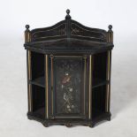 An Aesthetic Movement ebonised hanging corner cabinet, the panelled cupboard door with painted