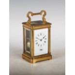 A late 19th century brass striking carriage clock with alarm, the white enamel dial with Roman