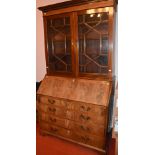 A George III mahogany bureau bookcase, the moulded cornice and dentil frieze above a pair of