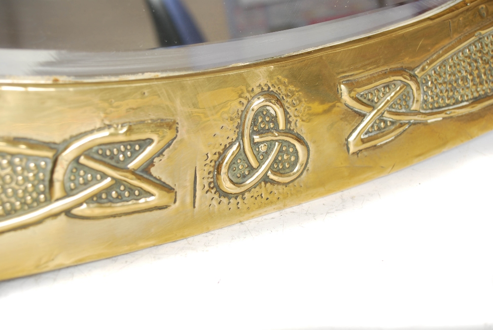 A Scottish Arts & Crafts brass wall mirror, the oval bevelled mirror plate within an embossed Celtic - Image 5 of 10