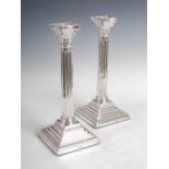 A pair of George V silver Corinthian column candlesticks, London, 1915, makers mark of HF, with