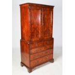 A George I walnut cabinet on chest, the moulded cornice above a pair of panelled cupboard doors,