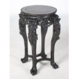 A Chinese dark wood jardiniere stand, Qing Dynasty, the circular panelled top above a pierced and