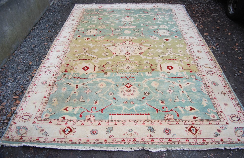 A Persian green ground carpet, 20th century, worked in red coloured threads with a large central