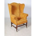 A 19th century mahogany wing armchair, the leather upholstered back and arms with brass studded