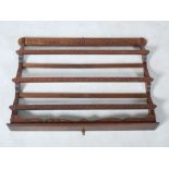 An Arts & Crafts hanging plate rack in the style of Alexander Ritchie, with carved Celtic knot-