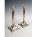 A pair of early 20th century silver plated Corinthian column candlesticks, with detachable drip