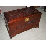 A Chinese camphor wood chest, late 19th/ early 20th century, the top and front panels carved with