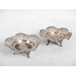 A pair of late 19th century Indian/ Burmese silver dishes, with embossed foliate decoration within a