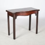 A George III mahogany serpentine tea table, the hinged rectangular top with a moulded edge above a