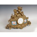 A late 19th century French ormolu and porcelain mounted mantle clock, the circular white enamel dial