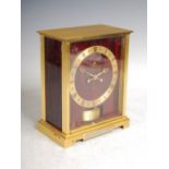 A Jaeger-Le Coultre Atmos clock, with red marbled dial and brass chapter ring bearing Roman