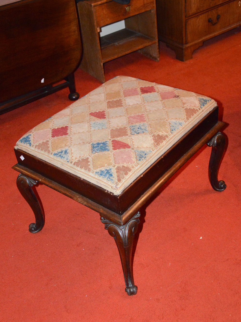 A Victorian rosewood rectangular stool, the drop in needlework upholstered top set into a mahogany