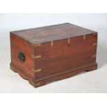 A late 19th/ early 20th century teak and brass bound coffer, the hinged top opening to a plain