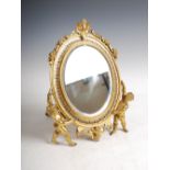 A late 19th century gilt bronze and champleve enamel dressing table mirror, the oval bevelled mirror
